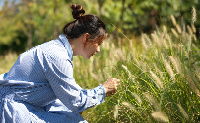 woman inspecting grass detail