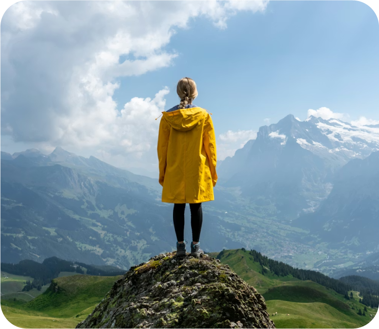 woman in yellow coat looking at mountain view